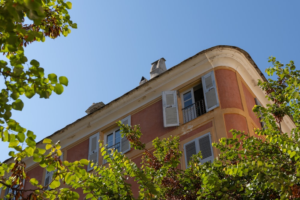 a tall building with windows and shutters on top of it