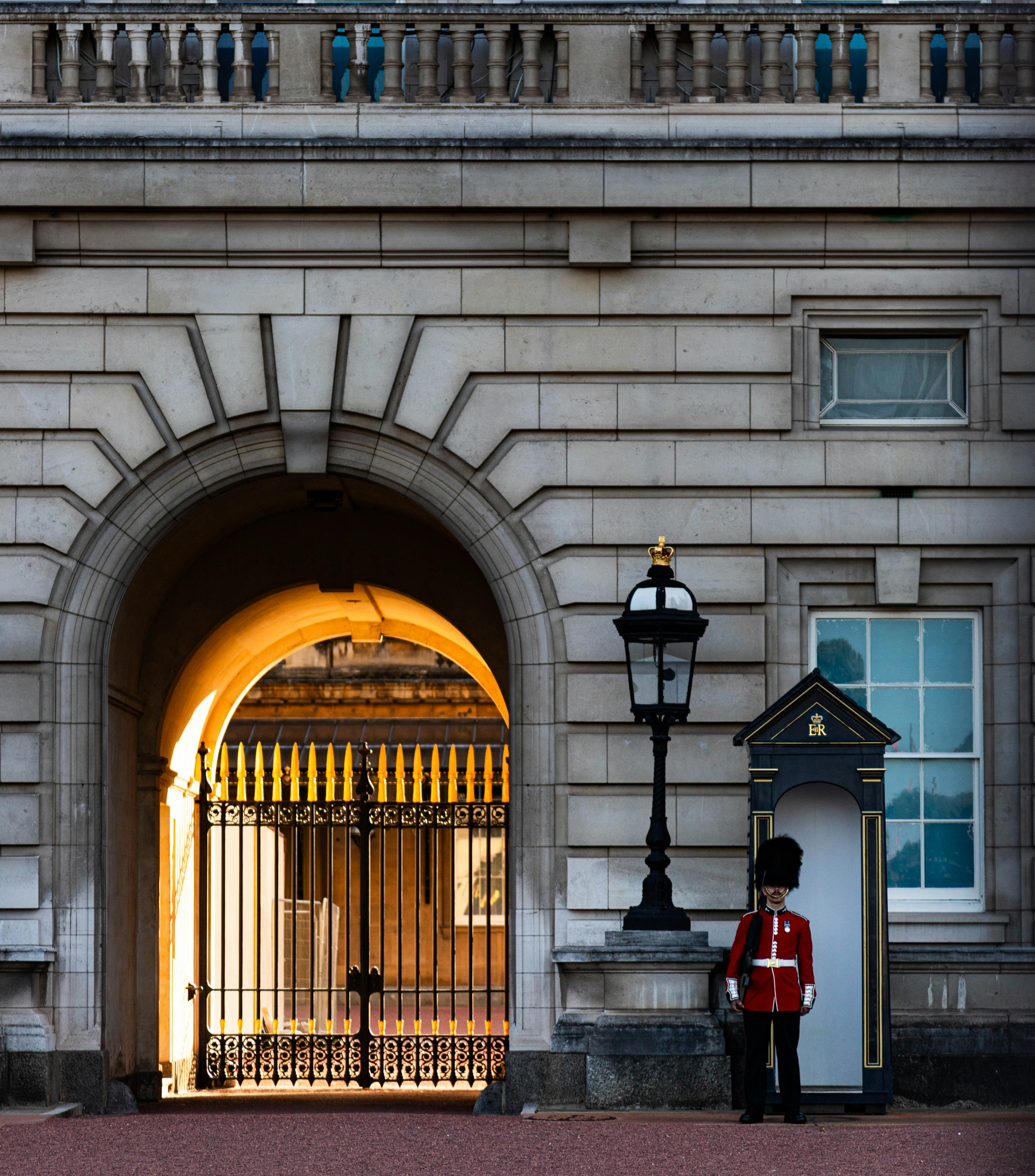 A guard stands in front of a gated entrance photo – Free London Image ...