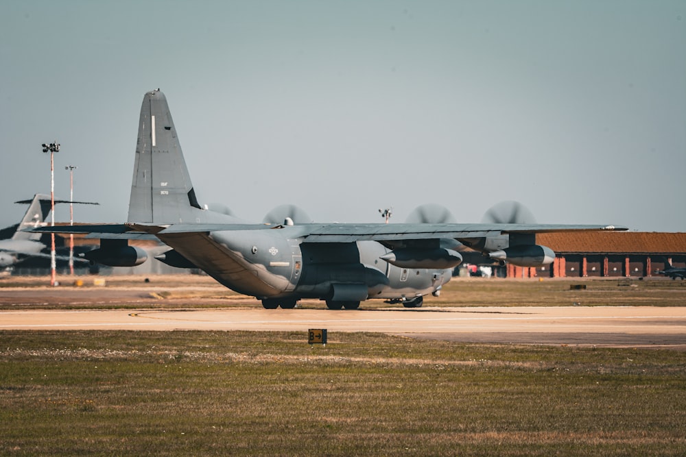 a large military jet sitting on top of an airport runway