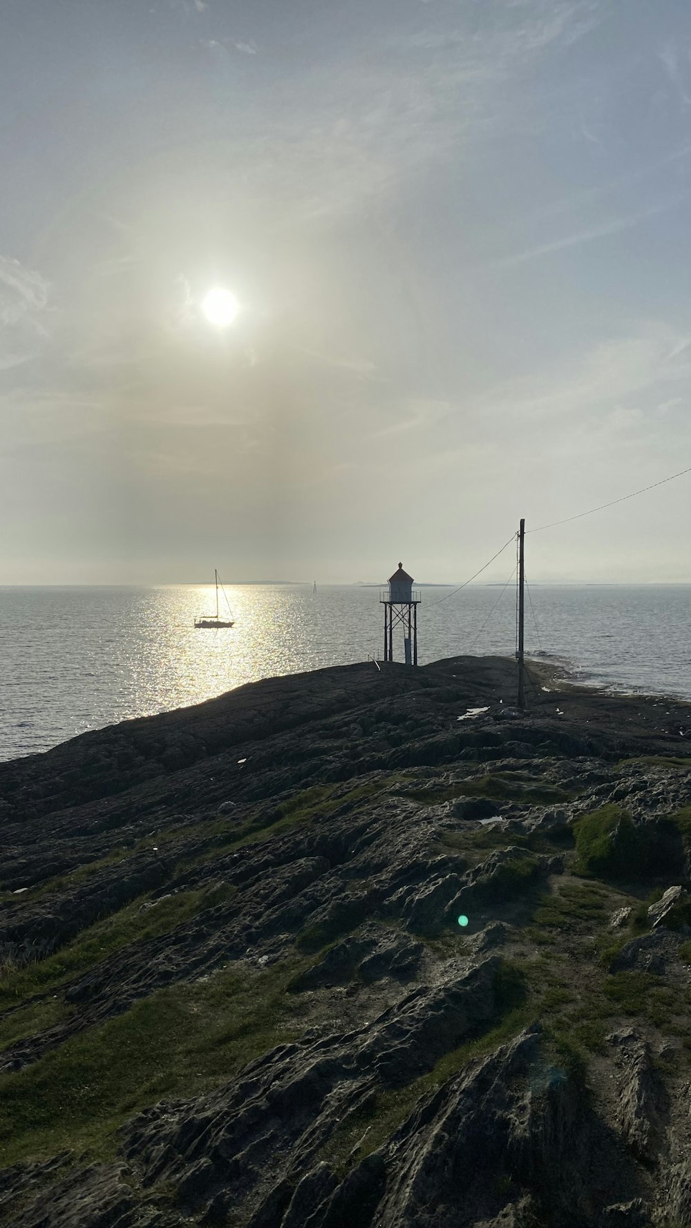 o sol está brilhando sobre o oceano e uma pequena cabana