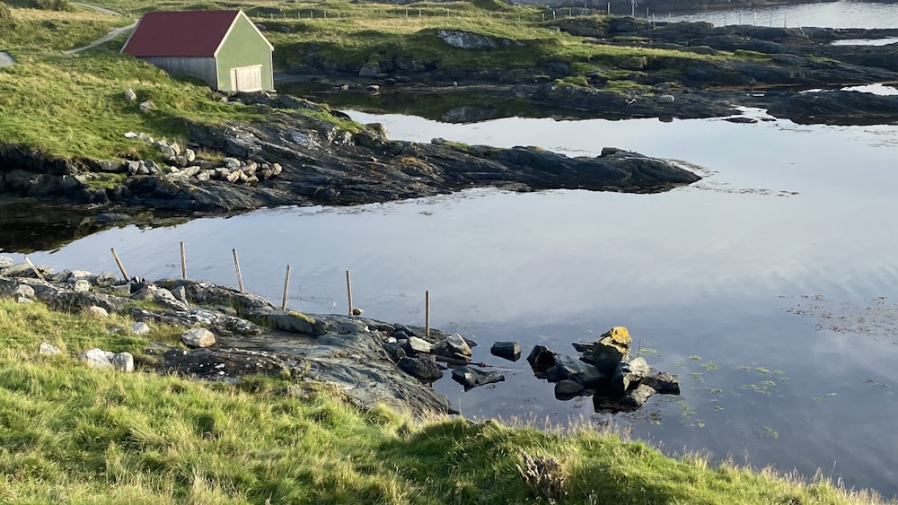 un plan d’eau avec une maison en arrière-plan