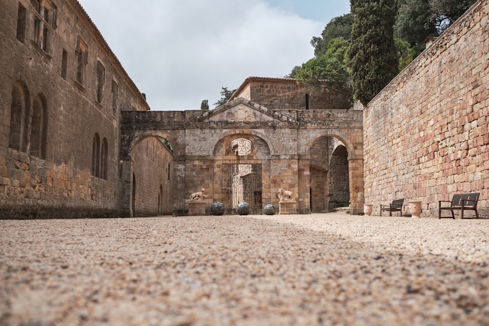 a stone courtyard with benches and a stone wall