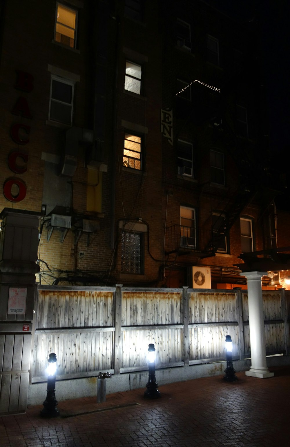 a row of fire hydrants sitting in front of a tall building