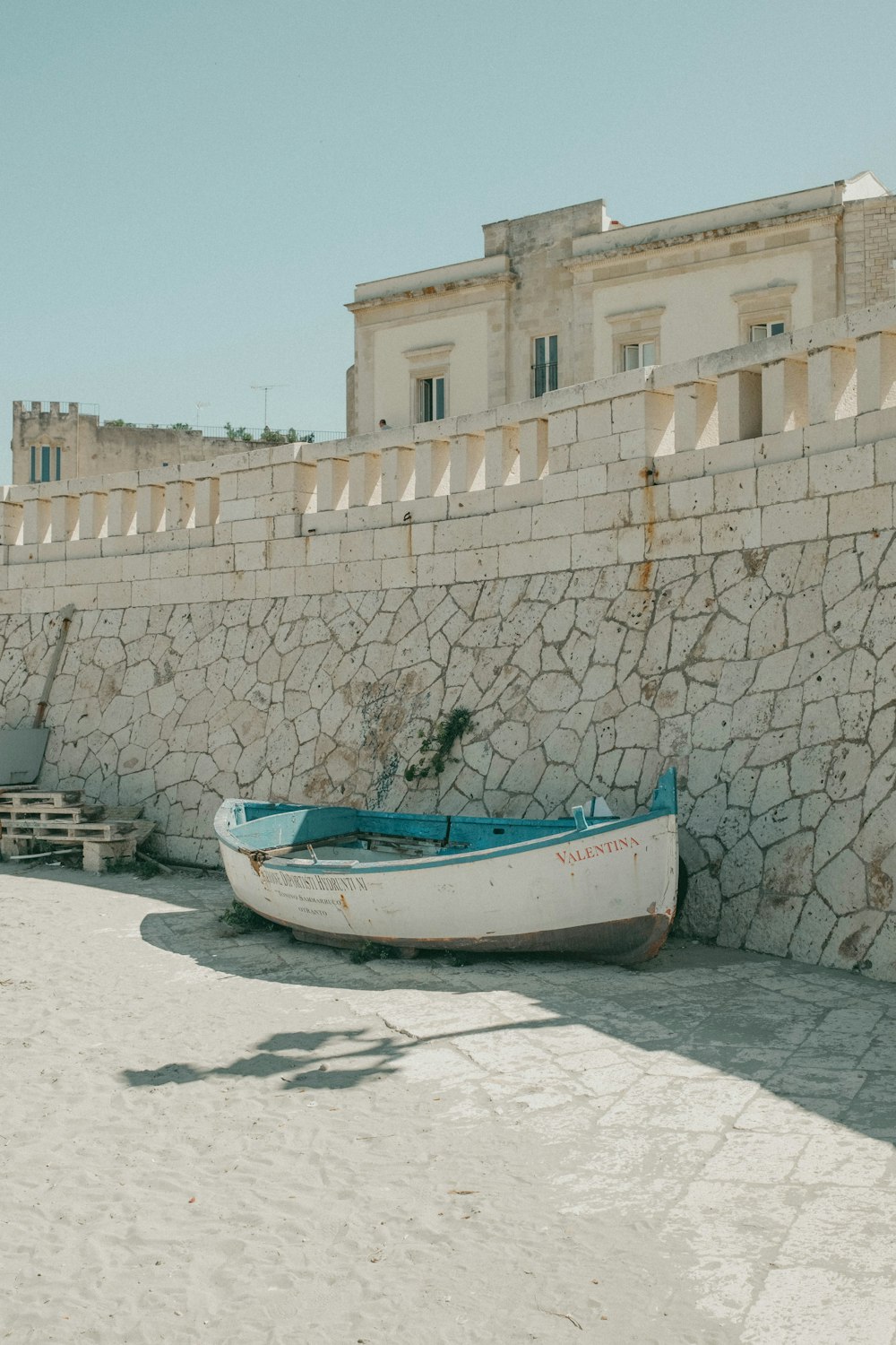 a white boat sitting on top of a sandy beach