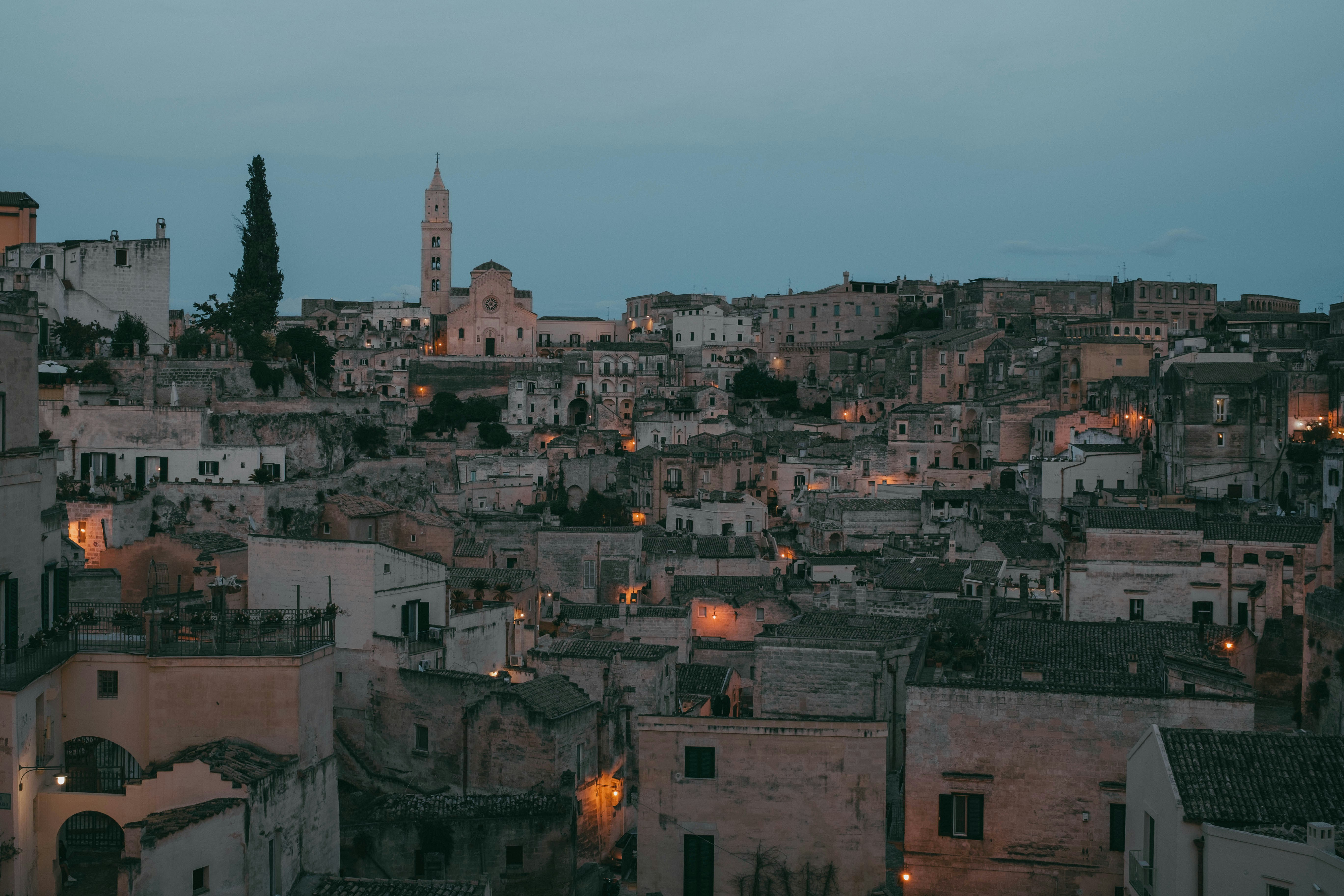 a city is lit up at night with a clock tower in the background, 