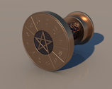A bronze cylindrical object resembling a spool or reel, featuring a circular face with a star-shaped design in the center. The outer edge displays various astrological symbols arranged in a circle. The surface finish appears metallic and polished.