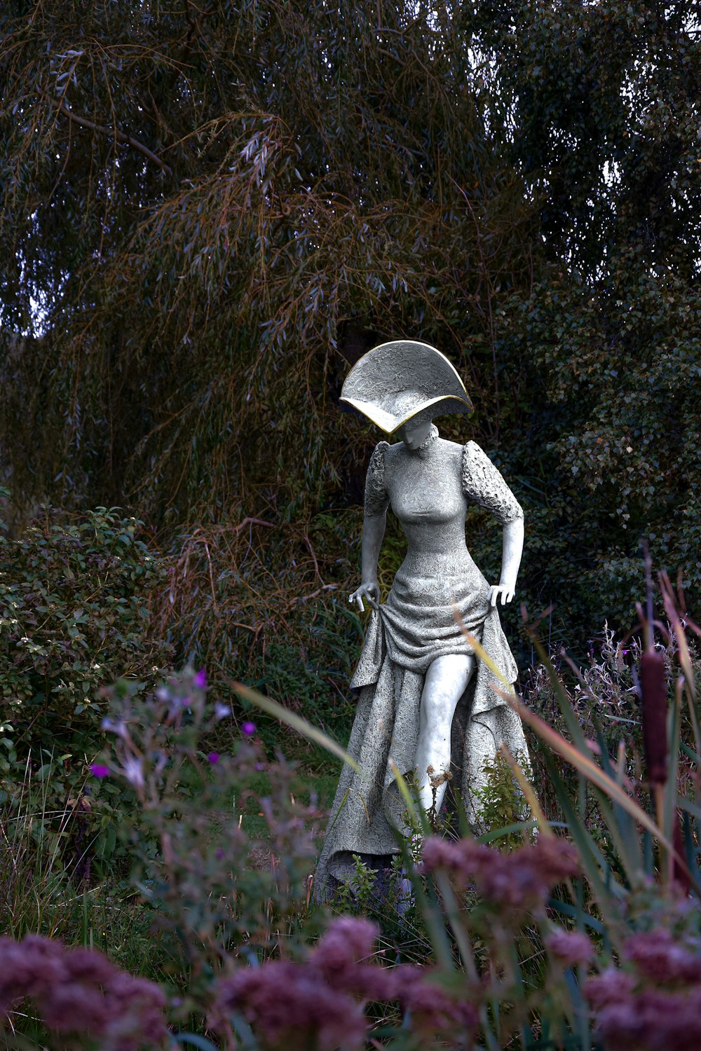 a statue of a woman holding an umbrella