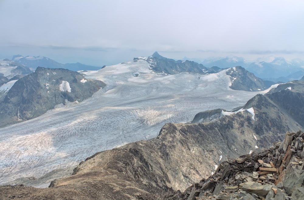 Un hombre parado en la cima de una montaña cubierta de nieve