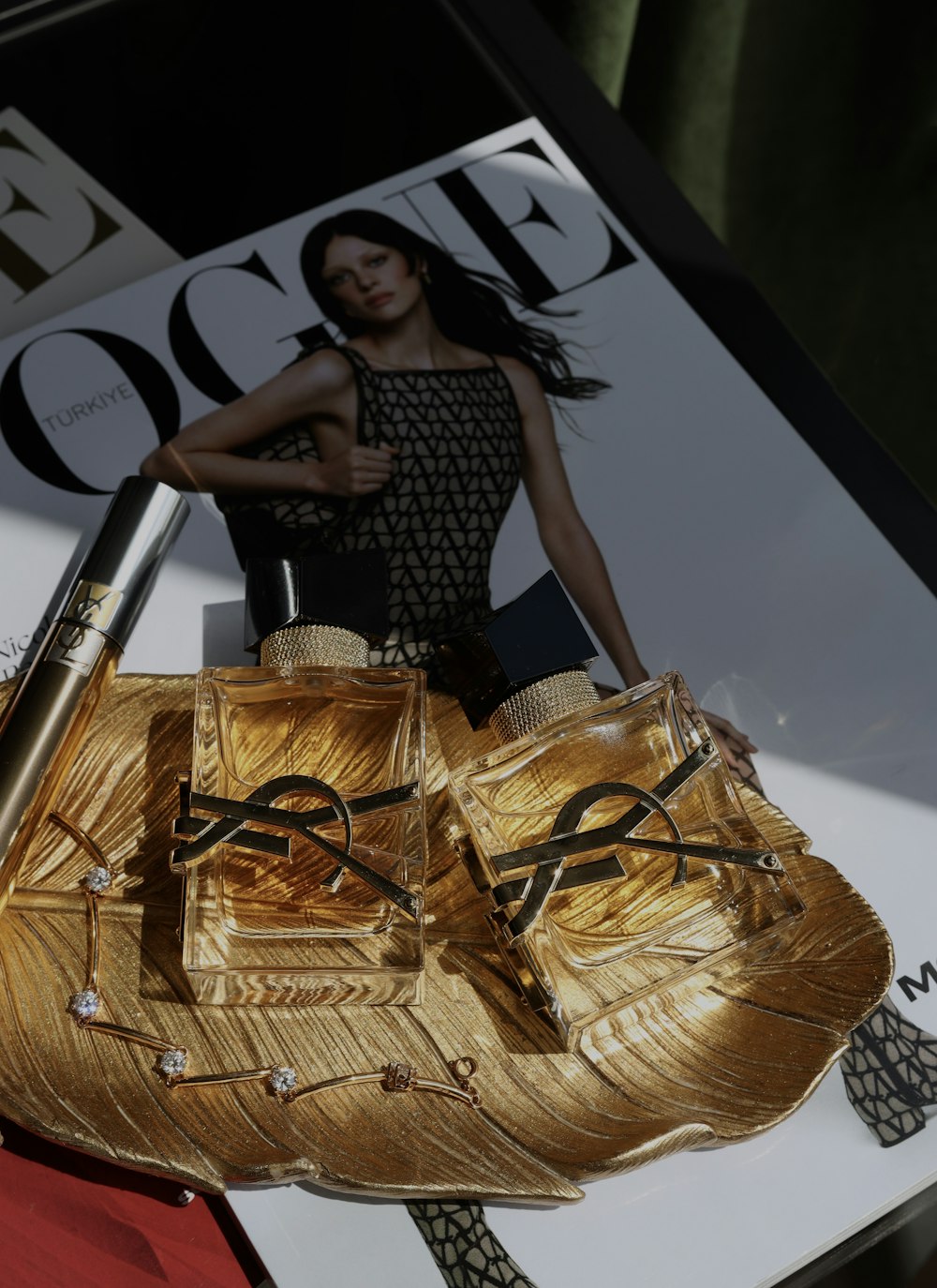 a woman holding a gold purse on top of a magazine
