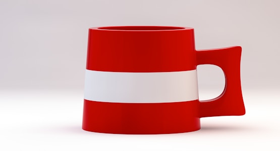 A red mug with a white horizontal stripe in the center, featuring a uniquely angled handle. The background is a plain, light gradient, highlighting the bold colors of the mug.