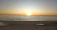 A serene image of a person meditating at sunrise on a quiet beach.