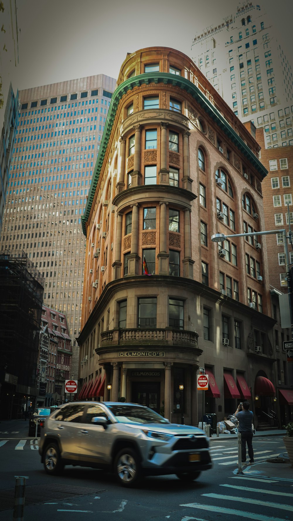 a car driving down a street next to tall buildings