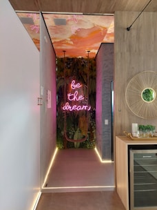a long hallway with a neon sign on the wall