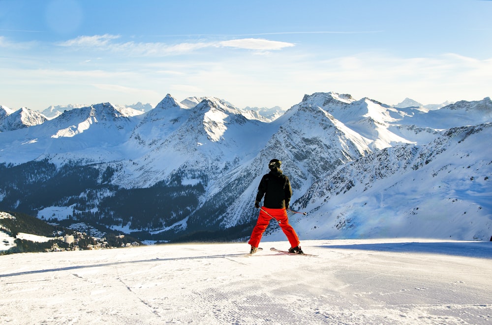 a man standing on top of a snow covered slope