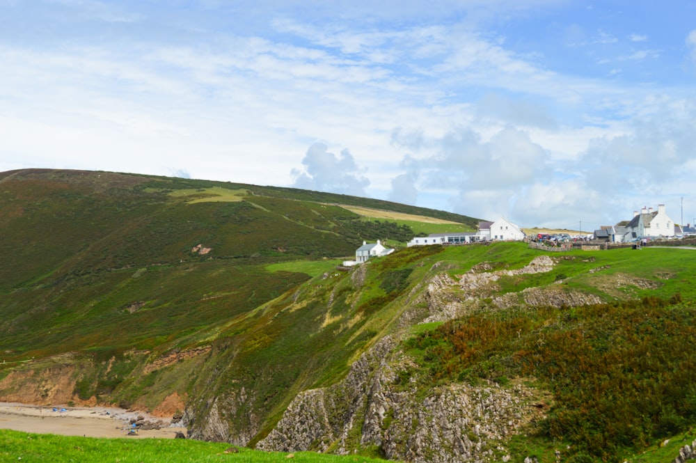 a grassy hill with houses on top of it