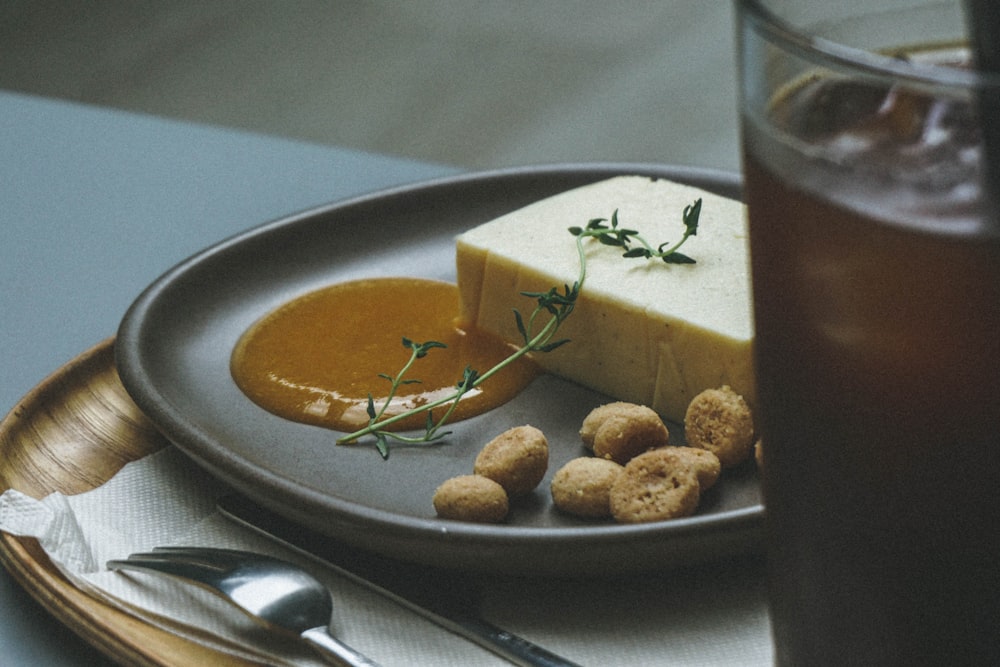 a plate of food on a table next to a glass of tea
