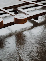 A board game with wooden elements and round pieces featuring Chinese characters. The surface is smooth and slightly reflective, suggesting it might be wet or polished.
