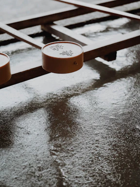 A board game with wooden elements and round pieces featuring Chinese characters. The surface is smooth and slightly reflective, suggesting it might be wet or polished.