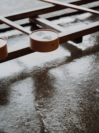 A board game with wooden elements and round pieces featuring Chinese characters. The surface is smooth and slightly reflective, suggesting it might be wet or polished.