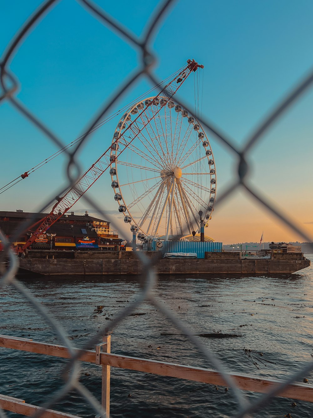 a large ferris wheel sitting next to a body of water