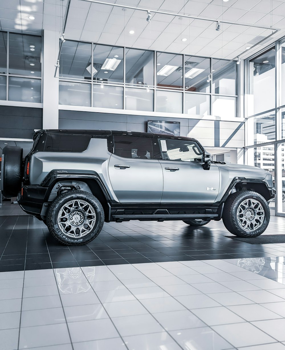 a silver jeep is parked inside of a building