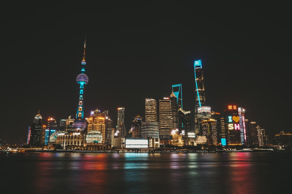 a city skyline at night with lights reflecting off the water