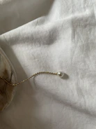 Minimalist gold necklaces layered over ivory white silk.