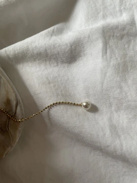 Minimalist gold necklaces layered over ivory white silk.