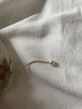 A serene workspace with handcrafted jewellery pieces and soft natural light highlighting delicate gold and beige tones.