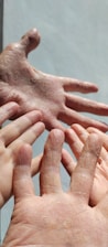 A close-up of diverse hands applying moisturizer, highlighting natural skin textures.