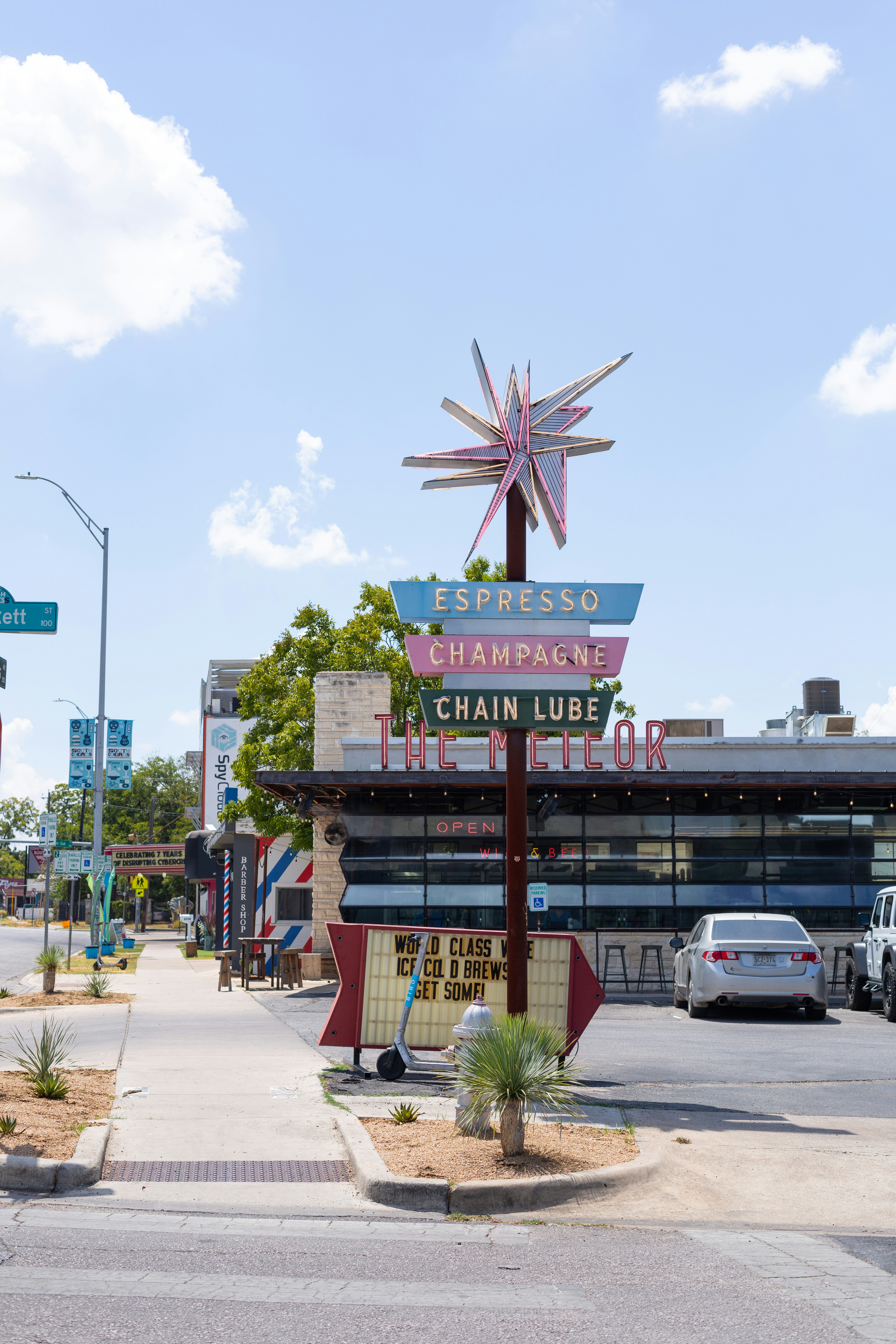 a street corner with a sign and a car parked on the side of the road