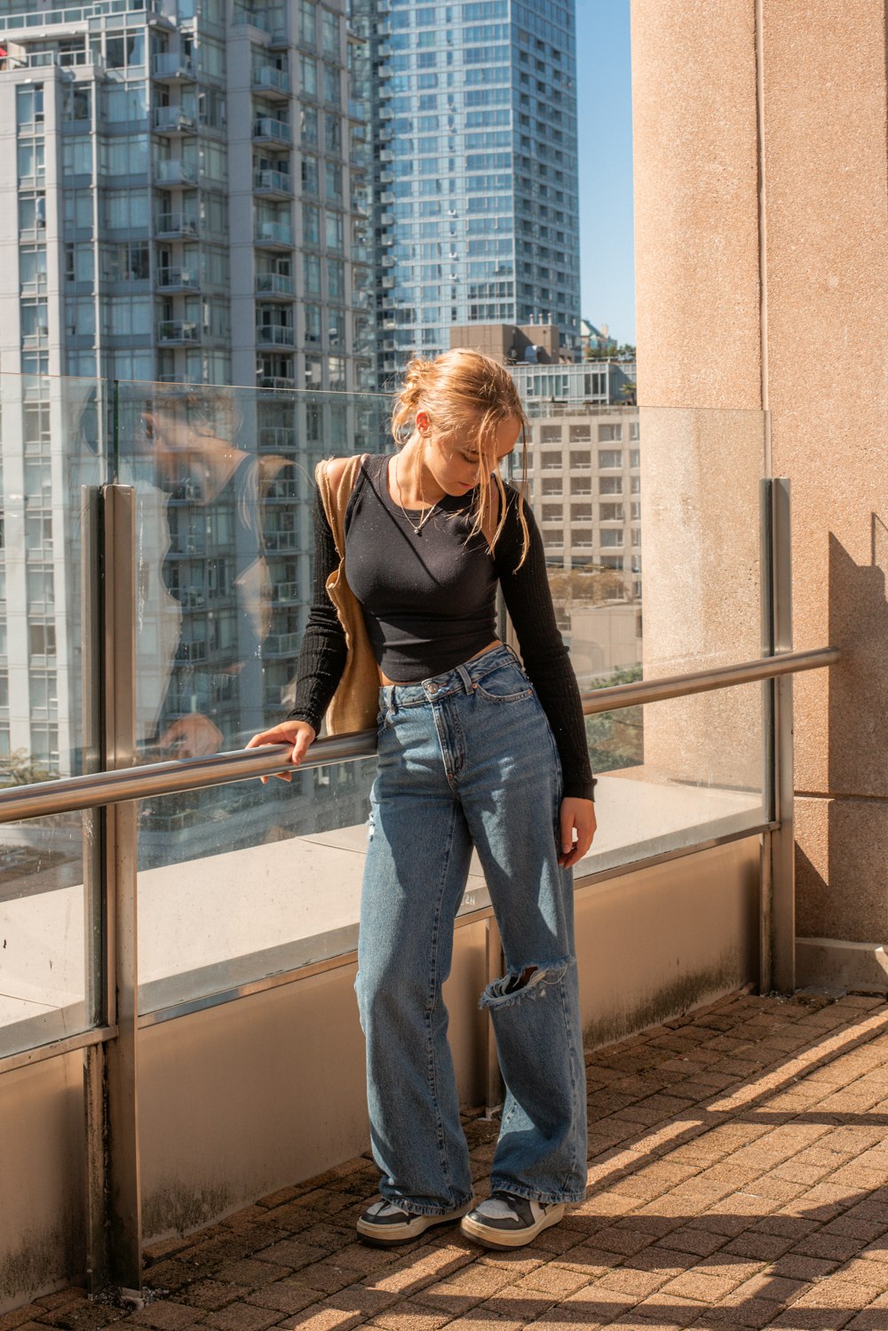 a woman leaning against a railing in front of a cityscape