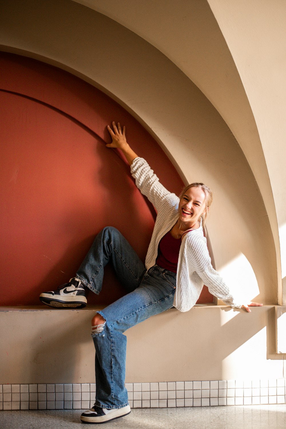 a woman leaning against a wall and smiling