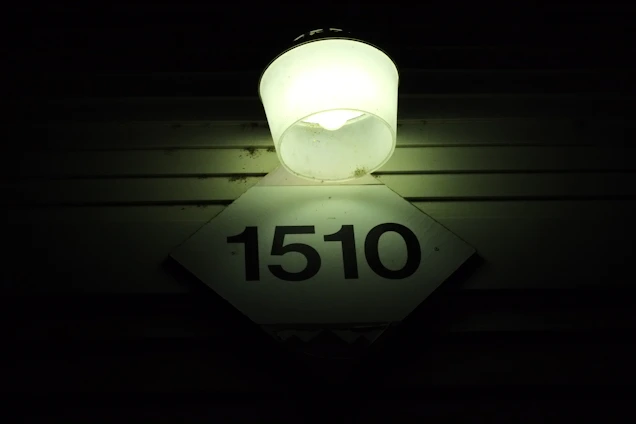 Close-up of a bright reflective address sign mounted on a modern home, glowing softly in the evening light.