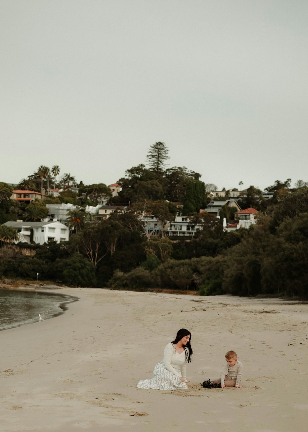 a woman and a child sitting on a beach