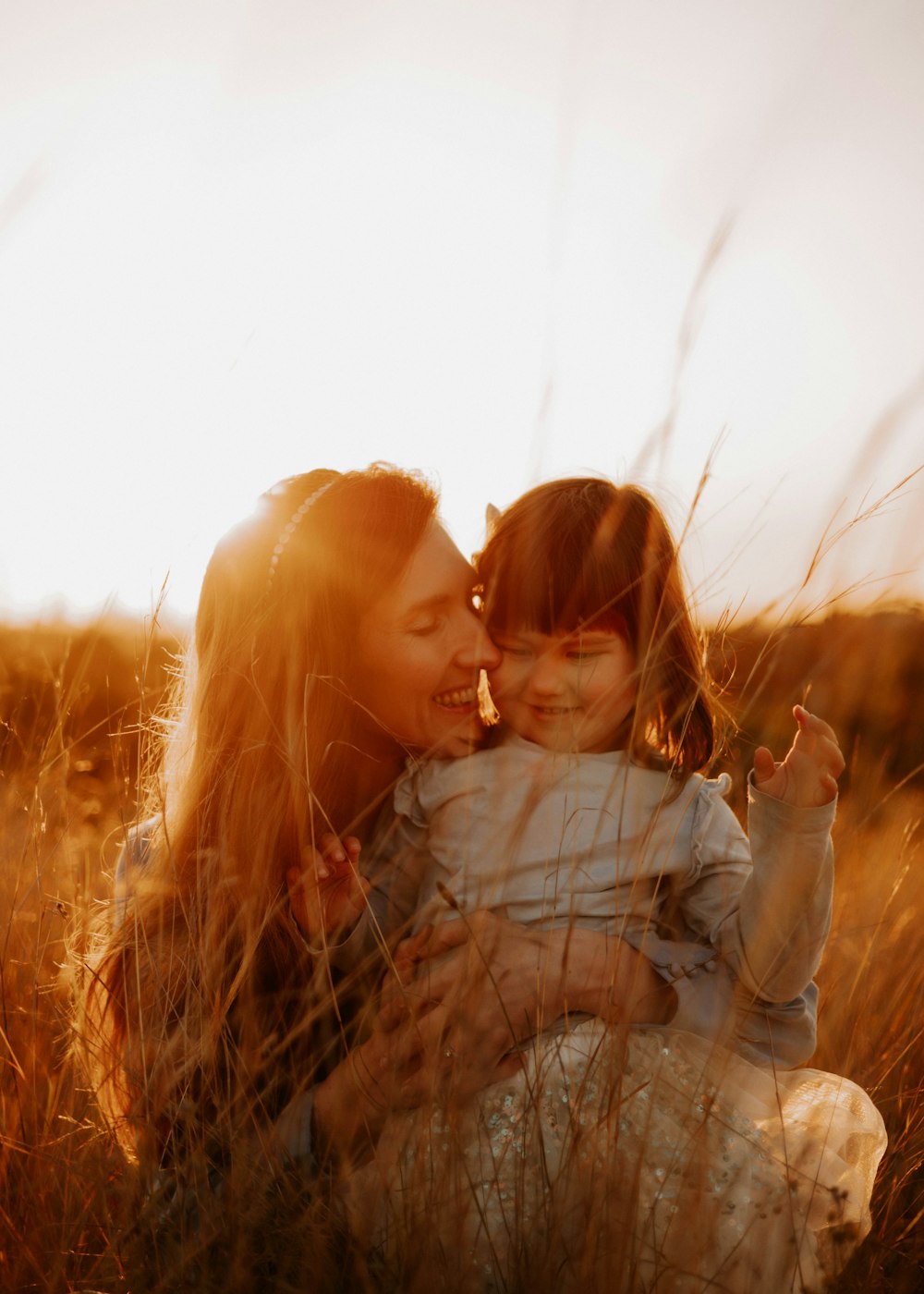 a woman holding a small child in a field