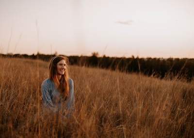 A peaceful outdoor portrait of a woman embracing nature during golden hour.