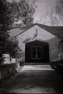 Black and white photo of the family who lived in the house during the 1950s, smiling on the front porch.