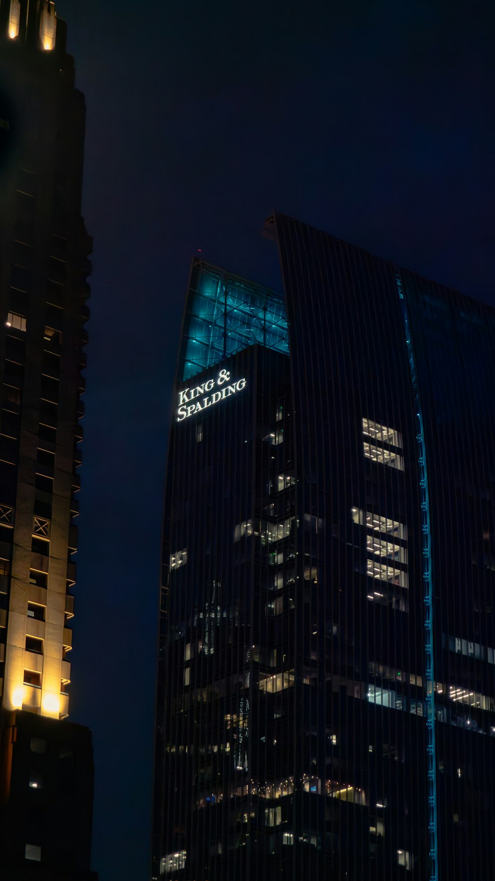 a very tall building with a lit up sign on it's side