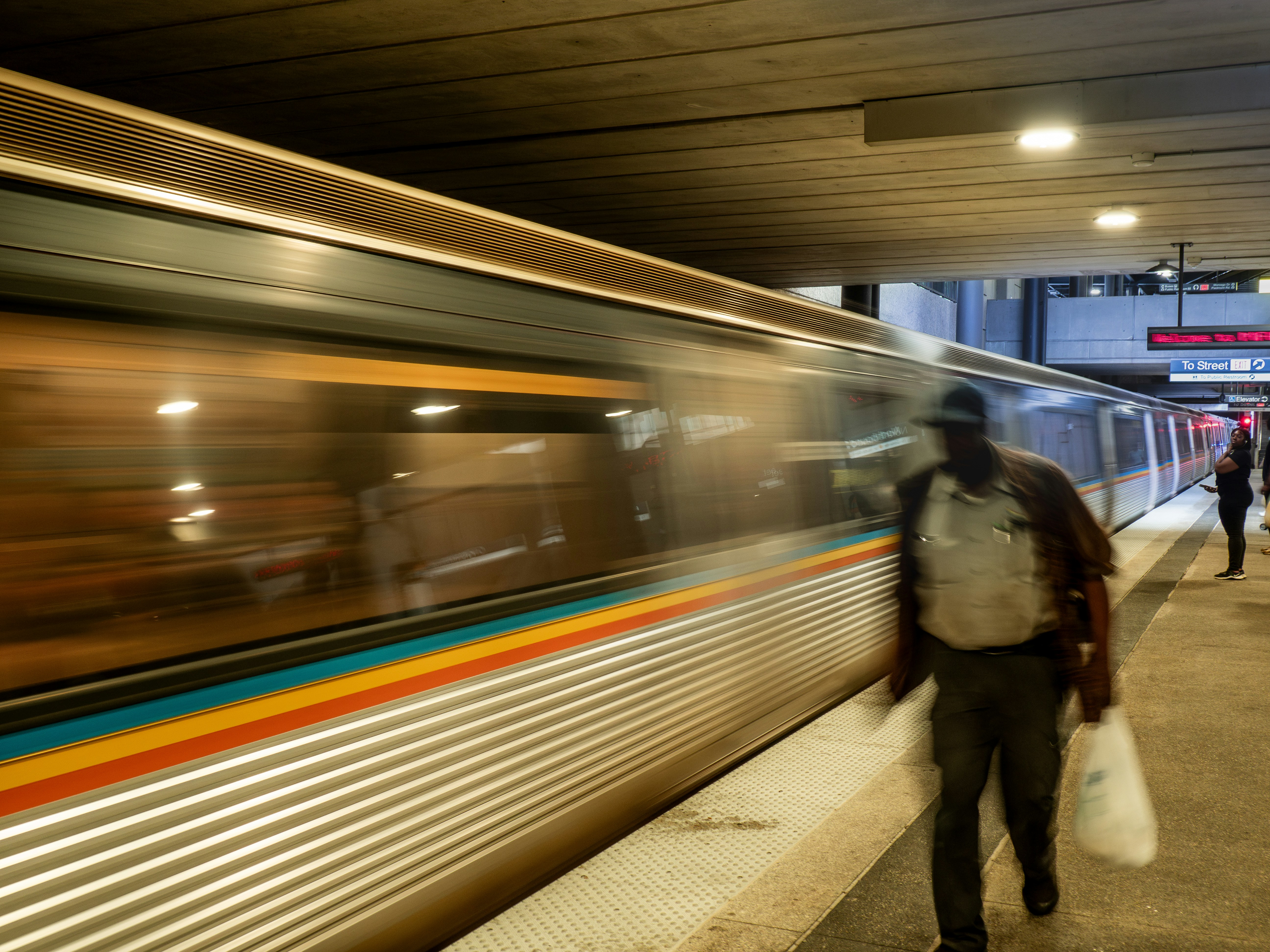 a man with a bag is walking next to a train
