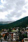Wide-angle view of multiple chalets scattered across a lush green valley.