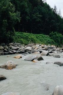 A peaceful setting with natural stones by a flowing river.