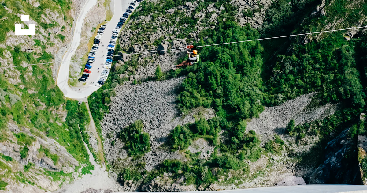 A person on a rope in the middle of a mountain photo – Free Land Image ...