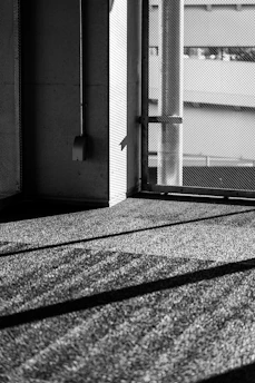 A stark monochrome photojournalistic image capturing an industrial scene with sharp contrasts and deep shadows.