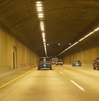 two cars driving down a tunnel in the middle of the night