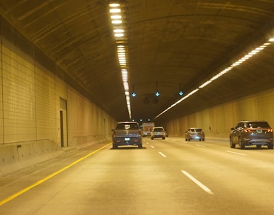 two cars driving down a tunnel in the middle of the night