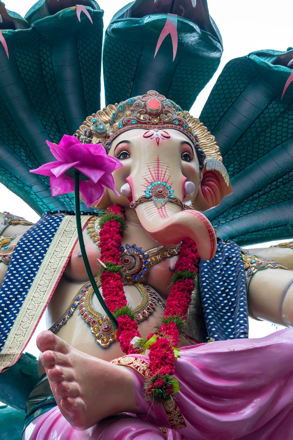 a statue of an elephant with a flower in its trunk