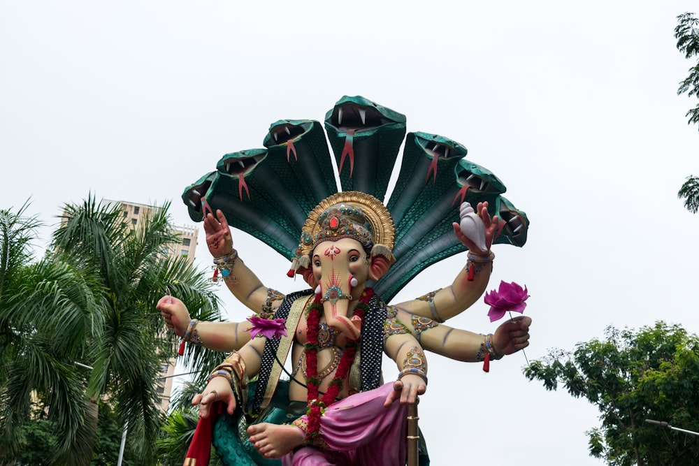 a statue of an indian god holding a flower