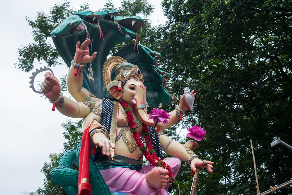 a statue of an elephant with an umbrella on it's back