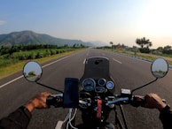 A rider's perspective showing the open road ahead with clear blue skies.